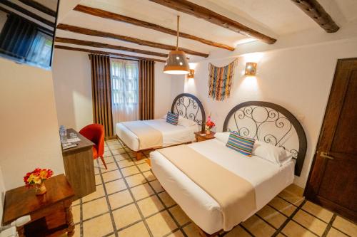 um quarto de hotel com duas camas e uma mesa em Vilas Insight Hotel Machupicchu em Machu Picchu