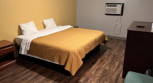 1 dormitorio con 1 cama y aire acondicionado en la pared en BUDGET MOTEL, en Danville