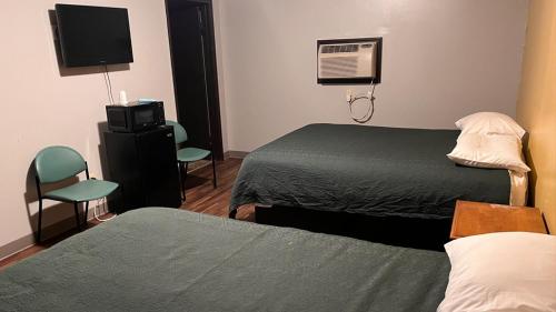 a hotel room with two beds and a television at BUDGET MOTEL in Danville
