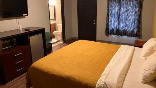 1 dormitorio con 1 cama, vestidor y TV en BUDGET MOTEL en Danville