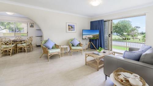 een woonkamer met een bank en een tafel bij Walk to Surf Beach - Ground floor apartment - Bribie Horizons Boyd St, Woorim in Woorim