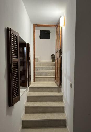 a hallway with stairs with a door and a stairwayngthngthngthngthngth at Maison d'hôtes DAR DRISS in Matmata
