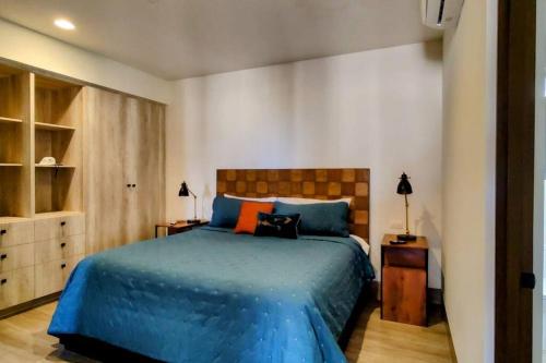 卡波圣卢卡斯Amazing 2BR Pool/Jacuzzi/Beach/ Resort/10Min Cabo的一间卧室配有一张带蓝色床单和橙色枕头的床。