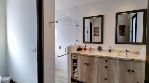 卡波圣卢卡斯Amazing 2BR Pool/Jacuzzi/Beach/ Resort/10Min Cabo的配有两个水槽和两面镜子的浴室