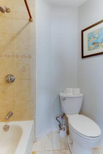 a white bathroom with a toilet and a shower at NEW! Boston Condo Near MBTA, 3 Mi to Fenway! (U2) in Boston
