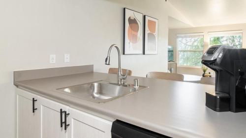 um balcão de cozinha com um lavatório e um micro-ondas em Landing Modern Apartment with Amazing Amenities (ID9692X16) em Everett