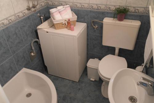 ein Badezimmer mit einer weißen Toilette und einem Waschbecken in der Unterkunft Seaside house for families with children Rogoznica - 22156 in Rogoznica