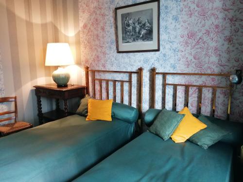 a bedroom with two beds and a table with a lamp at Gîte Nuillé-sur-Vicoin, 4 pièces, 6 personnes - FR-1-600-194 in Nuillé-sur-Vicoin