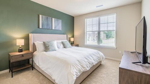 een slaapkamer met een bed en een flatscreen-tv bij Landing Modern Apartment with Amazing Amenities (ID7516X47) in Littleton