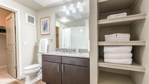 een badkamer met een wastafel, een toilet en een spiegel bij Landing Modern Apartment with Amazing Amenities (ID7516X47) in Littleton