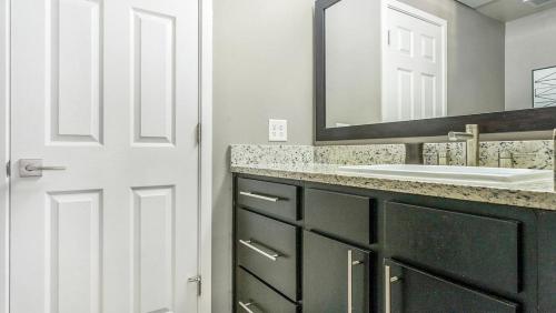 uma casa de banho com um lavatório e um espelho em Landing Modern Apartment with Amazing Amenities (ID5789X48) em El Paso