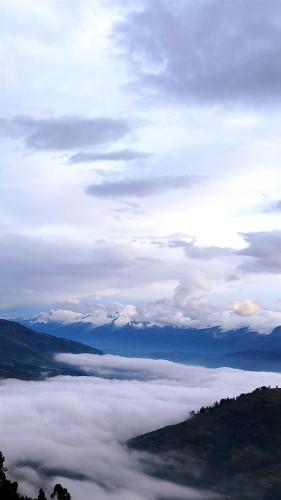 a view of a foggy valley with snow covered mountains at Mirador Willcacocha lodge - Glamping - Camping in Huaraz