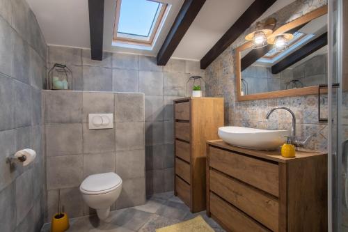 a bathroom with a sink and a toilet and a mirror at Secluded house with a swimming pool Kosljun, Pag - 22238 in Pag
