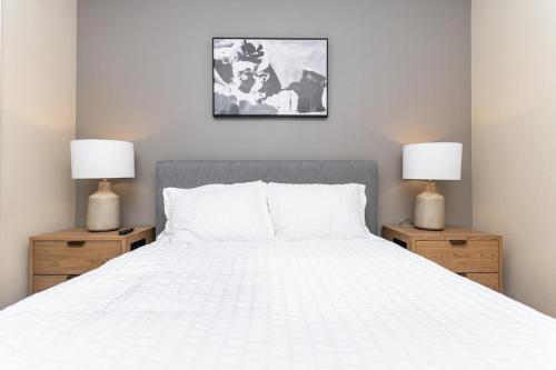 1 dormitorio con 1 cama blanca y 2 mesitas de noche en Landing Modern Apartment with Amazing Amenities (ID3883), en Carrollton