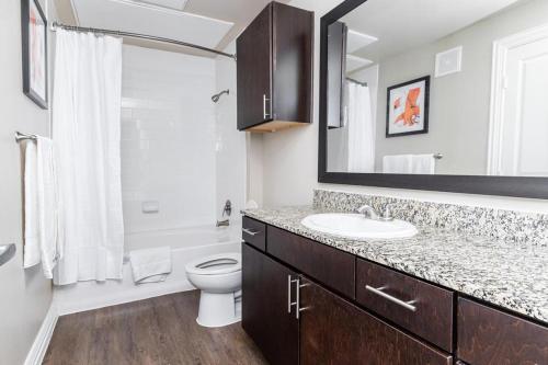 W łazience znajduje się umywalka, toaleta i lustro. w obiekcie Landing Modern Apartment with Amazing Amenities (ID3883) w mieście Carrollton