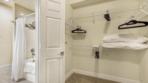 Zimmer mit einem Schrank mit einem Bett und einer Dusche in der Unterkunft Landing Modern Apartment with Amazing Amenities (ID6447X41) in Houston