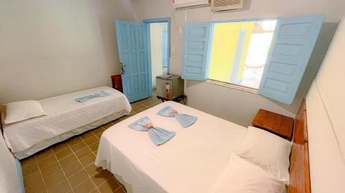 two beds in a room with blue shutters at Recanto das Estrelas in Marau