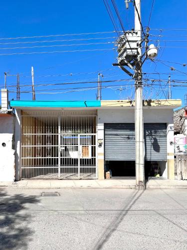 a building with a garage with a gate and a pole at Casa Huerta in Ciudad Fernández