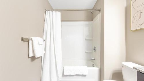 a bathroom with a shower with a white shower curtain at Landing Modern Apartment with Amazing Amenities (ID9436X35) in Fort Wayne