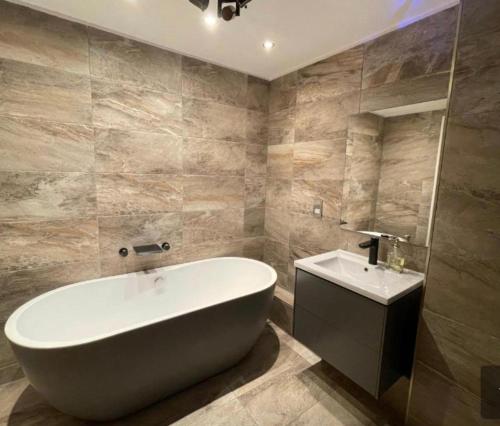 łazienka z dużą wanną i umywalką w obiekcie Holiday Apartment In Old Town w Edynburgu