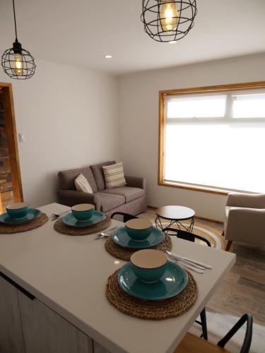 a living room with a table with plates on it at M House Pichilemu in Pichilemu