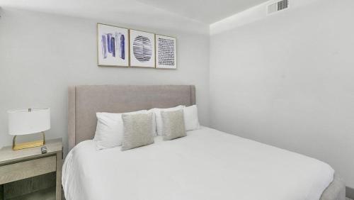 1 dormitorio con cama blanca y colcha blanca en Landing Modern Apartment with Amazing Amenities (ID7967X54), en Plano