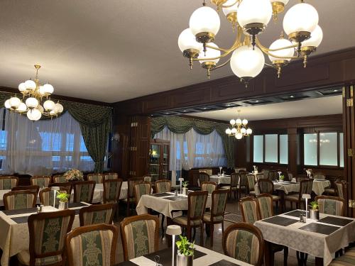 a dining room with tables and chairs and chandeliers at GRAND HOTEL SERGIJO RESIDENCE superior Adult only luxury boutique hotel in Piešťany