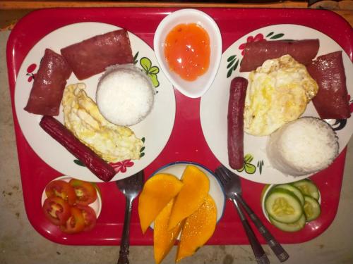a red tray with breakfast food on it at Don Leo's BnB in Esperanza