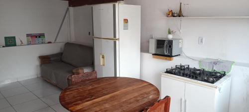 małą kuchnię ze stołem i lodówką w obiekcie G.LO Loft AP 04 w mieście Ponta Porã
