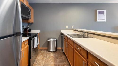 cocina con fregadero y nevera de acero inoxidable en Landing Modern Apartment with Amazing Amenities (ID1223X281) en Milwaukee
