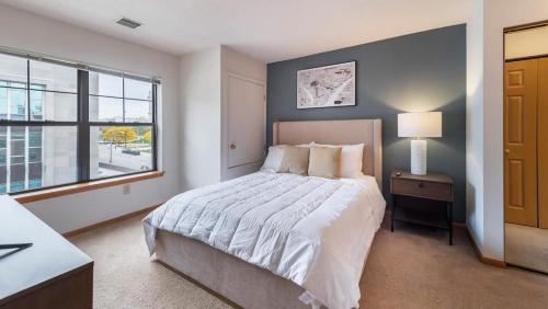 Un dormitorio con una cama grande y una ventana en Landing Modern Apartment with Amazing Amenities (ID1223X281) en Milwaukee