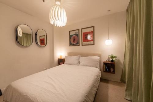 a bedroom with a white bed and two mirrors at Loft on Collins/Swanston - 2 storey - 2 bed 2 bath in Melbourne