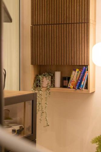 a shelf on a wall with books on it at Loft on Collins/Swanston - 2 storey - 2 bed 2 bath in Melbourne