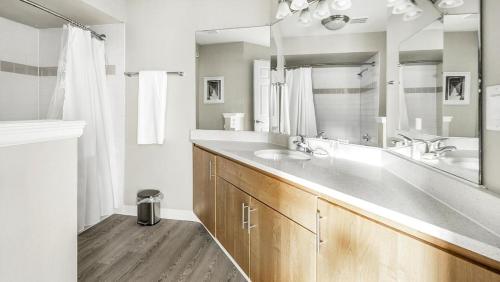 La salle de bains est pourvue d'un lavabo et d'un grand miroir. dans l'établissement Landing Modern Apartment with Amazing Amenities (ID7578X85), à Highlands Ranch