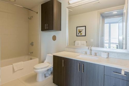 Landing Modern Apartment with Amazing Amenities (ID512) في دالاس: حمام مع حوض ومرحاض وحوض استحمام