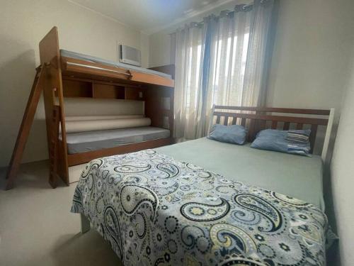 a bedroom with a bed and bunk beds in it at A Casa in Maricá