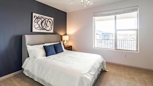sypialnia z białym łóżkiem i oknem w obiekcie Landing Modern Apartment with Amazing Amenities (ID7813X12) w Aurorze