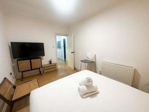 a room with a bed and a flat screen tv at Flat 1 Stay In Aldgate in London