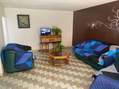 sala de estar con cama y sofá en Paulora, en Hidalgo del Parral