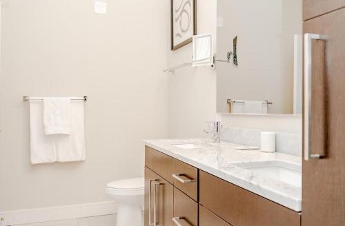 uma casa de banho branca com um lavatório e um WC em Landing Modern Apartment with Amazing Amenities (ID2685X5) em Beachwood