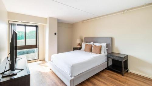 メドフォードにあるLanding Modern Apartment with Amazing Amenities (ID1225X470)の白いベッドルーム(ベッド1台、テレビ付)