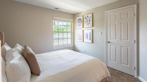 - une chambre blanche avec un lit et une fenêtre dans l'établissement Landing Modern Apartment with Amazing Amenities (ID1193X713), à Indianapolis