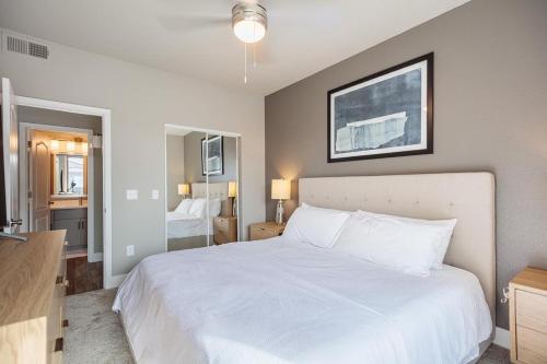 ein Schlafzimmer mit einem großen weißen Bett und einem Spiegel in der Unterkunft Landing Modern Apartment with Amazing Amenities (ID8723X6) in Phoenix
