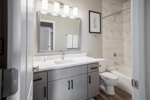 ein Badezimmer mit einem Waschbecken, einem WC und einem Spiegel in der Unterkunft Landing Modern Apartment with Amazing Amenities (ID8723X6) in Phoenix