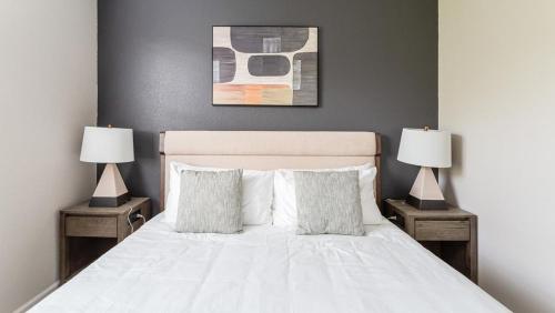 - une chambre avec un lit blanc et 2 lampes dans l'établissement Landing Modern Apartment with Amazing Amenities (ID8175X59), à Fort Myers