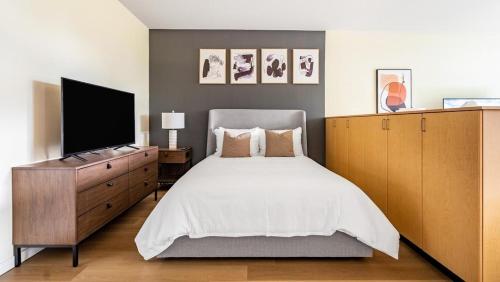 een slaapkamer met een bed en een flatscreen-tv bij Landing Modern Apartment with Amazing Amenities (ID9955X51) in Everett
