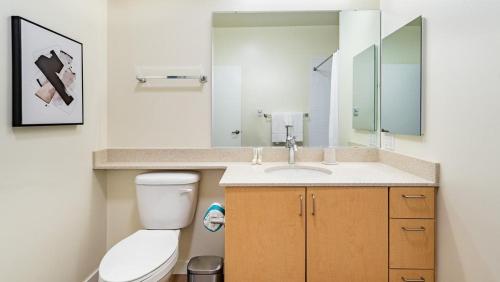 y baño con aseo, lavabo y espejo. en Landing Modern Apartment with Amazing Amenities (ID9955X51) en Everett