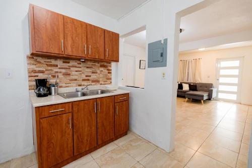 a kitchen with a sink and a living room at Casa Luquillo in Fajardo