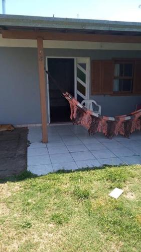 une maison dotée d'une terrasse couverte avec une corde à linge en face de celle-ci dans l'établissement Casa - ótima localização, à Capão da Canoa