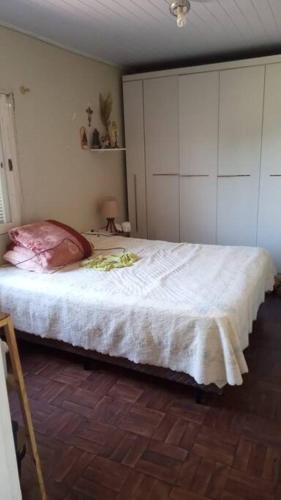 卡龐達卡諾阿的住宿－Casa - ótima localização，一间卧室配有一张带白色橱柜的大床